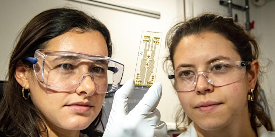 Two female scientists  in a lab with safety glasses on