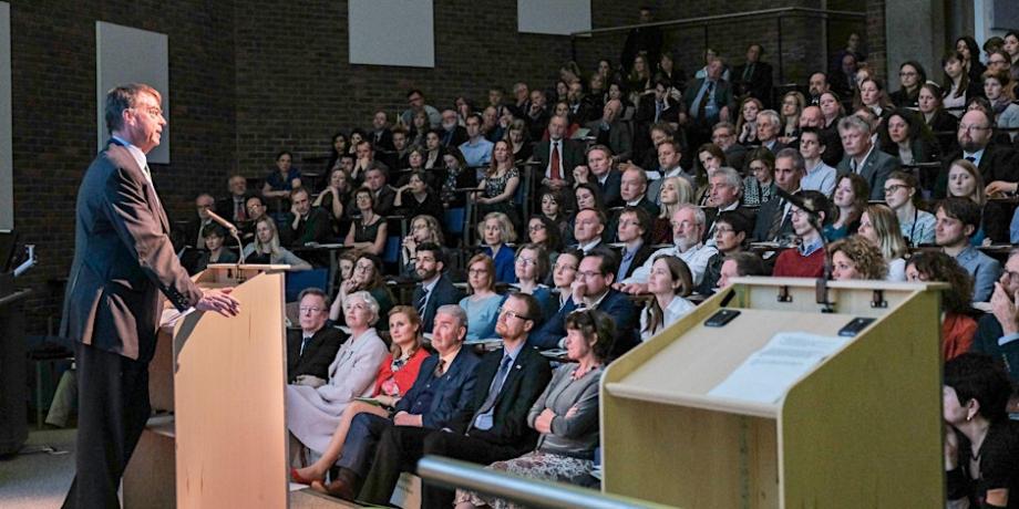 A man at a lecturn talking to an audience