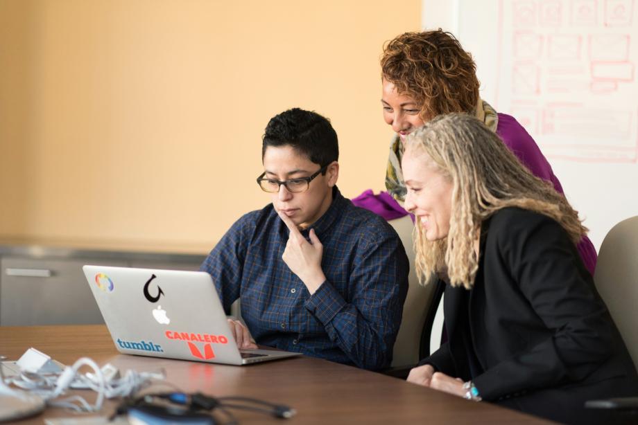 Three diverse women looking at a laptop.