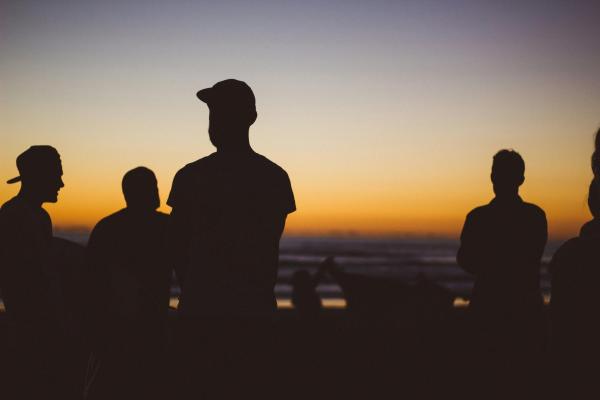 Group of men standing in the sunset