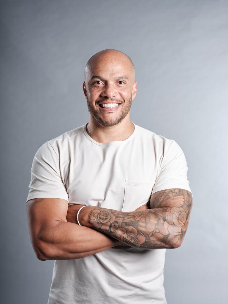 Harry Jameson, Tom's Trust Ambassador, smiling with arms folded