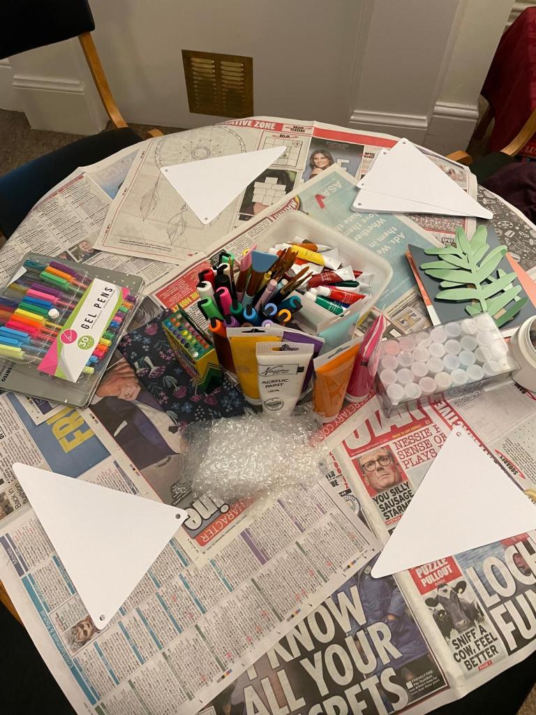 A table containing crafting materials, including felt pens and crayons