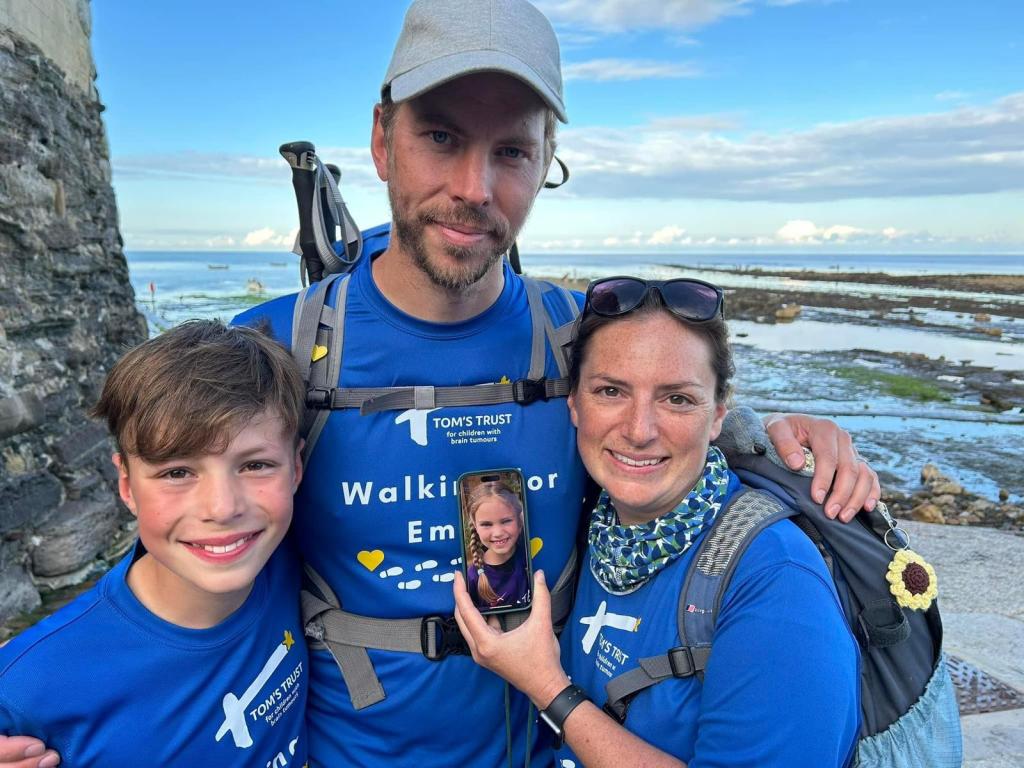 Smith family walking with Emily's picture on a phone