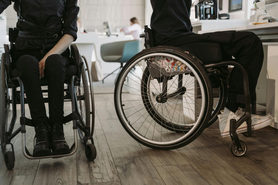 Two people in wheelchairs working at desks.