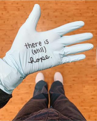 gloved hand with a message written on the palm - 'There is still hope'
