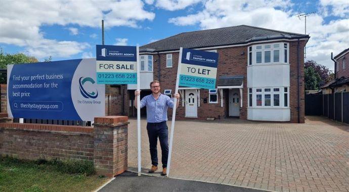 man holding for sale sign 