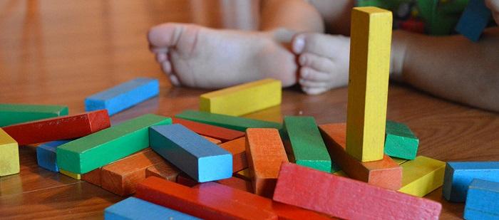 building blocks on floor with a child's feet in view_ Pixabay