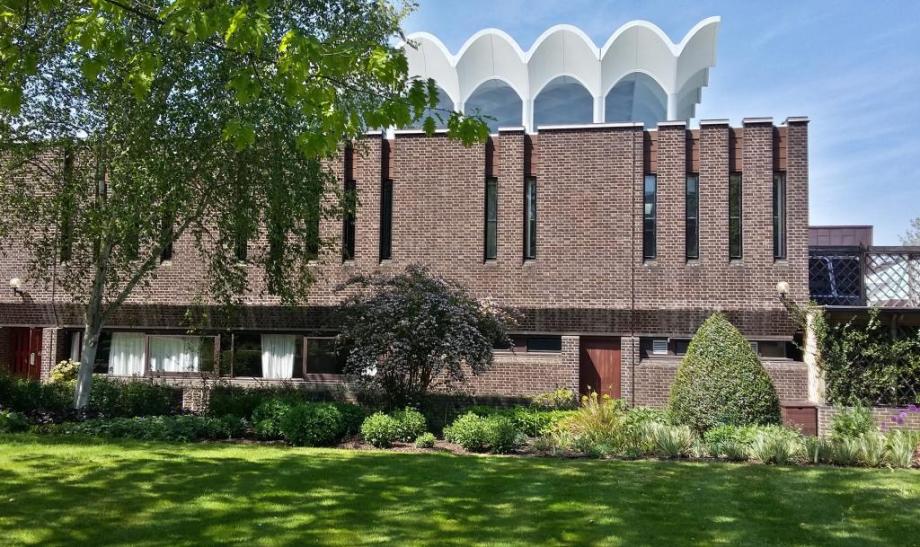 Brick building with a white roof that resembles the sails on a boat, FItzwilliam College, Cambridge Dining Hall