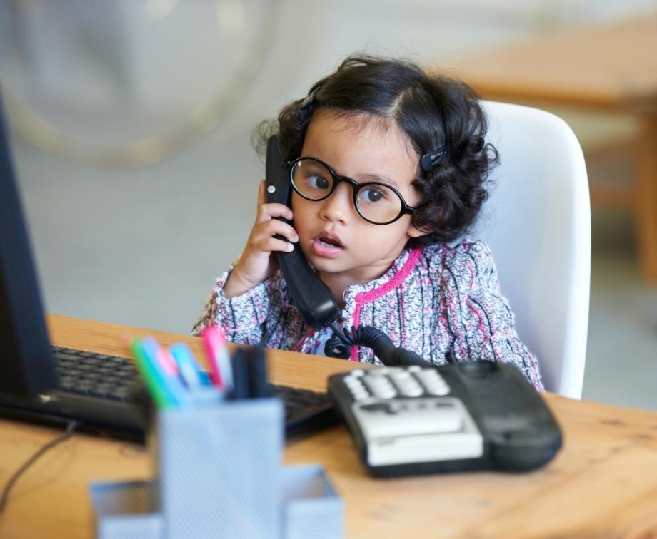 Young girl at a desk on a work phone call