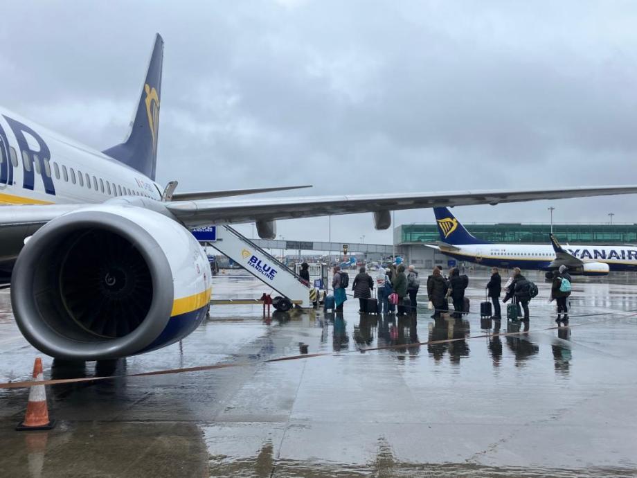 A queue of passengers waiting to board a Ryanair plane in the rain