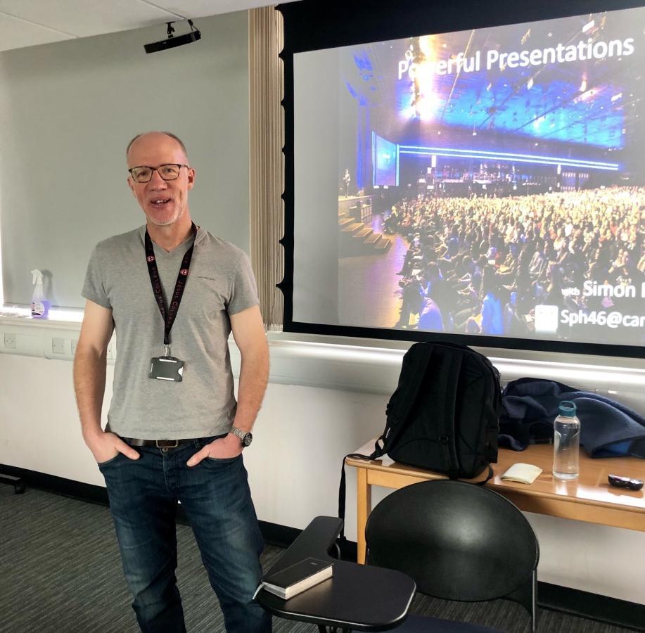 Simon in front of presentation screen