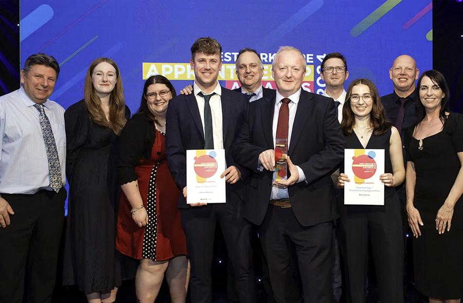 Reliance apprentices holding awards along with the team