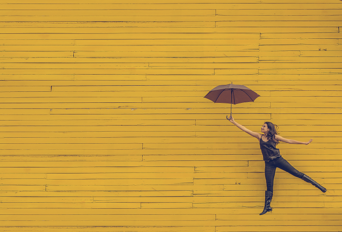 Woman with umbrella with yellow plank background