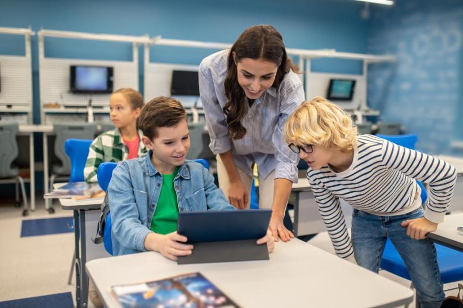 Teacher with students looking at tablet | zincvych